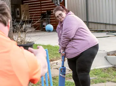 disabled woman and boy are playing cricket in our SIL home