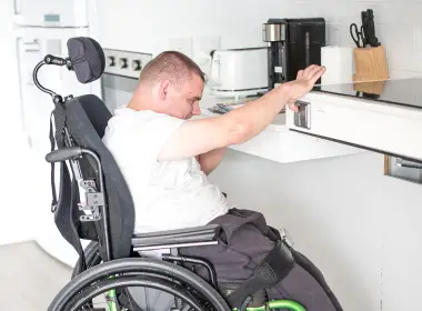 Disabled boy in a wheelchair in the kitchen